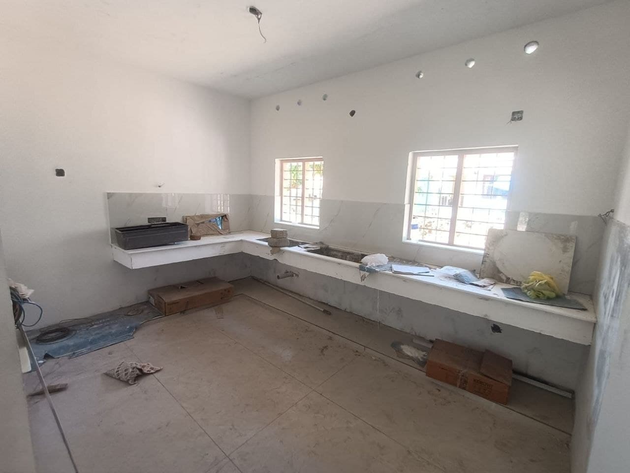 Kitchen mid-renovation — bare marble counter shell, unfinished walls