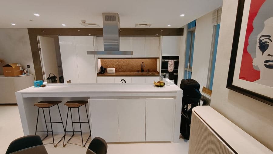 Handleless white kitchen island with waterfall edge