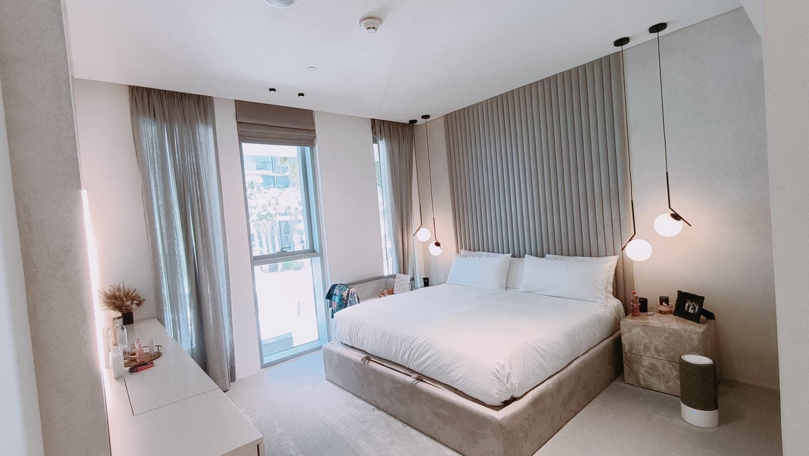Master bedroom with channel-tufted headboard and sea-view balcony