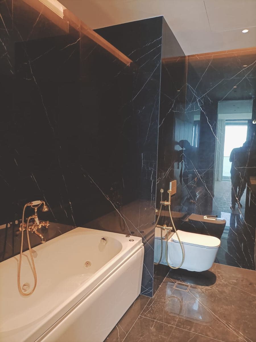 White marble ensuite with cylindrical pedestal basin